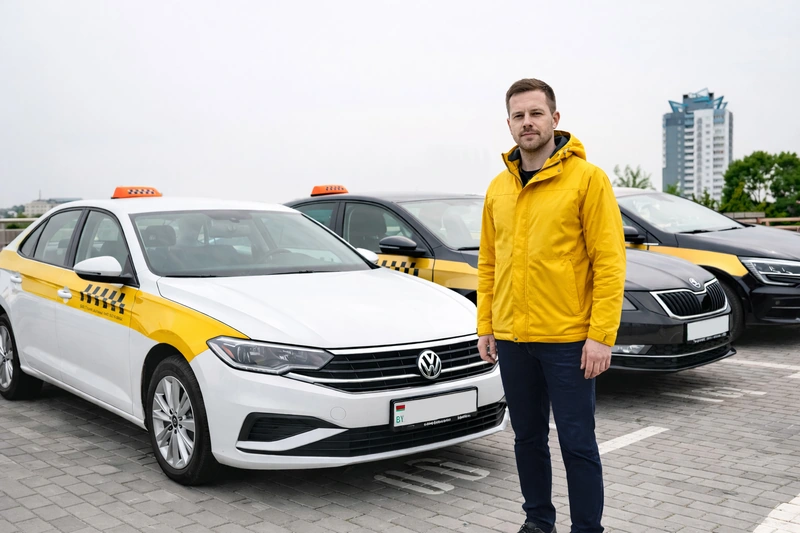 Водитель рядом с автомобилями таксопарка